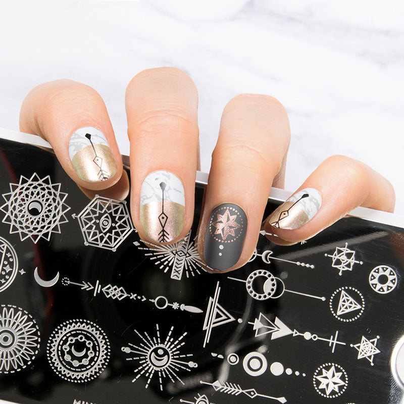 Elegant geometric manicure with hand holding nail stamping plate